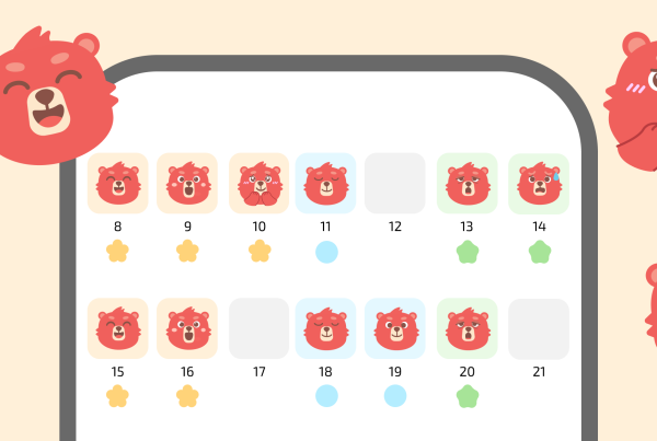 Календарь настроения на месяц в приложении для здорового образа жизни, показывающий ежедневную историю эмоций, с иконками талисманов в виде красных медведей и цветовыми индикаторами настроения для отслеживания прогресса.